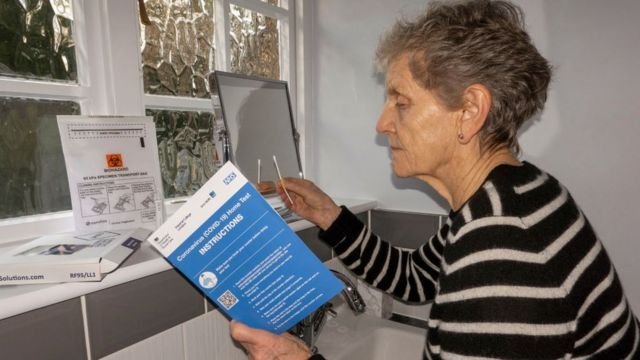 Anh: Một phụ nữ sử dụng bộ tự xét nghiệm Covid-19 tại nhà