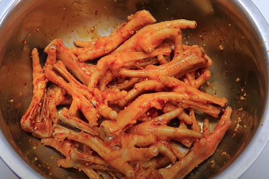 Chân gà nướng muối ớt có mùi vị cay nồng cùng hương thơm lan tỏa, hấp dẫn và chinh phục mọi thực khách. Để có món chân gà nướng muối ớt ngon, bạn cần biết cách làm sao cho nguyên liệu và các loại gia vị có sự hòa hợp nhất định. Vì vậy, hãy bỏ túi ngay những chia sẻ của Nghề Bếp Á Âu để có cho mình một món ăn thơm ngon hết sẩy nhé.   Chân gà nướng muối ớt thơm ngon và hấp dẫn mọi thực khách. Ảnh: Internet Chân gà nướng muối ớt không chỉ là món ăn vặt bình dân được đông đảo chị em yêu thích mà nó còn là mồi nhậu khoái khẩu của đấng mày râu. Cách chọn chân gà ngon  Chân gà là loại thực phẩm có thể chế biến nên nhiều món ăn thơm ngon và hấp dẫn. Tuy nhiên, với sự tồn tại những bất cập về chất lượng thực phẩm trên thị trường, để đảm bảo chọn mua được đúng chân gà ngon và sạch, bạn cần chú ý những điều sau: - Khi mua, nên chọn chân gà có màu trắng hồng tự nhiên, không có màu sắc lạ như đốm đỏ, xanh. Sờ vào chân gà thấy da đàn hồi, không bị nhớt. - Dùng tay bóp đều chân gà, nếu thấy chắc thịt là chân gà ngon. Bên cạnh đó, bạn cũng cần áp dụng những mẹo sau đây để phân biệt được chân gà tươi và chân gà bom nước: - Chân gà bơm nước thường béo mập và không có nếp nhăn trên da. - Dùng tay bóp nhẹ, nếu thấy chân gà mềm nhũn, căng phồng bất thường thì đó là chân gà bơm nước. - Khi tuốt nhẹ từ lòng bàn chân xuống, bạn sẽ thấy chân gà bị bơm nước rĩ ra từng giọt nước. - Đặc biệt, chân gà bơm nước sẽ có 4 ngón duỗi căng và to. Bơm càng nhiều nước thì các ngón sẽ tách nhau ra rõ rệt. Cách sơ chế và chẻ chân gà không bị nát  Chân gà được sơ chế sạch và chẻ đẹp mắt sẽ đảm bảo hình thức món ăn trông thẩm mỹ và hấp dẫn hơn. Do đó, khi mua chân gà về để nướng muối ớt, trước tiên bạn phải thực hiện các bước sau: - Bước 1: Chân gà cắt bỏ hết móng, đem ngâm với nước muối loãng, giấm khoảng 15 phút rồi rửa sạch. - Bước 2: Dùng dao khứa 1 đường từ lòng bàn chân đến cùi trên, sau đó tách phần vừa khứa ra rồi đập dập thật mạnh sao cho ống chân gà tách ra làm đôi mà phần ngón chân vẫn dính vào nhau.   Sơ chế chân gà đúng cách sẽ đảm bảo món ăn được thơm ngon và có hình thức bắt mắt. Ảnh: Internet Cách làm chân gà nướng muối ớt ngon như ngoài hàng  Nguyên liệu 500g chân gà 2 cây sả Ớt 1 củ tỏi, vài củ hành tím 1 ít gừng Giấm Nguyên liệu ăn kèm: rau răm, dưa leo, muối tiêu chanh hoặc muối ớt xanh,… Gia vị: Dầu hào, tương ớt, muối, muối tôm, đường, nước mắm, rượu trắng, bột xá xíu,…  Các bước thực hiện Bước 1: Sơ chế nguyên liệu Chân gà mua về sơ chế thật sạch rồi chẻ ra như hướng dẫn trên. Làm như vậy, chân gà sẽ thấm đều gia vị khi ướp và nướng mau chín hơn.  Sả làm sạch, phần gốc băm nhuyễn, phần lá cắt khúc. Gừng cắt lát mỏng. Ớt rửa sạch, băm nhuyễn. Hành tím, tỏi bóc vỏ, băm nhuyễn. Nguyên liệu ăn kèm làm sạch và để ráo. Bước 2: Luộc chân gà Đặt nồi nước lên bếp, đun sôi cùng sả cắt khúc và gừng cắt lát. Cho chân gà vào trụng 2 – 3 phút rồi vớt ra để ráo.   Luộc chân gà để loại bỏ mùi tanh hôi. Ảnh: Internet Bước 3: Cách ướp chân gà nướng  Chân gà sau khi sơ chế bạn cho vào âu ướp với hỗn hợp hành tím, tỏi, sả băm nhuyễn cùng 1 muỗng cà phê muối tôm, 1 muỗng cà phê ớt băm, 2 muỗng cà phê đường, 1 muỗng canh dầu hào, 1 muỗng canh tương ớt, 1 muỗng canh dầu ăn, 1 muỗng canh rượu trắng, 1 muỗng canh nước mắm, 1/3 muỗng cà phê bột xá xíu, trộn đều và để 20 phút cho chân gà ngấm gia vị.   Chân gà được ướp gia vị và có màu sắc hấp dẫn. Ảnh: Internet Bước 4: Cách nướng chân gà ngon  Sau khi đã ướp chân gà, chúng ta sẽ nướng trên bếp than hoa hoặc bếp nướng điện. Đặt từng chân gà lên vỉ nướng và trở liên tục để chân gà chín đều.    Đem chân gà đi nướng chín đều. Ảnh: Internet Món ăn sau khi hoàn thành, bạn cho ra đĩa, trang trí cùng rau răm, dưa leo cắt lát,… để trông bắt mắt hơn. Chân gà nướng muối ớt sẽ thật tuyệt vời nếu ăn kèm với muối tiêu chanh, muối ớt xanh hoặc tương ớt.   Trình bày món ăn và thưởng thức. Ảnh: Internet Lưu ý khi làm món chân gà nướng muối ớt - Bạn nên chọn chân gà tươi, sạch để món ăn thơm ngon tròn vị. - Cần luộc chân gà trước với sả và gừng để loại bỏ hoàn toàn mùi tanh và giúp chân gà được thẳng khi nướng chín, trông sẽ đẹp mắt hơn. - Ướp chân gà với chút rượu và dầu ăn sẽ giúp thành phẩm thơm mềm, hấp dẫn. - Bạn có thể thay bột xá xíu bằng màu gạch tôm để món ăn có màu sắc bắt mắt. - Ngoài chân gà nướng muối ớt, bạn có thể tìm hiểu thêm phương pháp làm chân gà nướng mật ong, chân gà nướng ngũ vị,… để có thêm nhiều sự lựa chọn cho mình. Với cách làm đơn giản được hướng dẫn bởi Nghề Bếp Á Âu, bạn sẽ có ngay món chân gà nướng muối ớt giòn cay ngon mê ly. Còn chần chờ gì mà không vào bếp thực hiện món ăn này. Và để học thêm nhiều bí quyết chế biến món ngon khác, bạn có thể tham gia các khóa học dạy nấu ăn tại Nghề Bếp Á Âu bằng cách điền thông tin đăng ký vào form bên dưới để được tư vấn khóa học phù hợp!