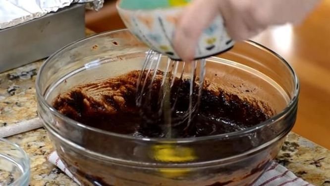 đập trứng vào bột làm bánh brownie