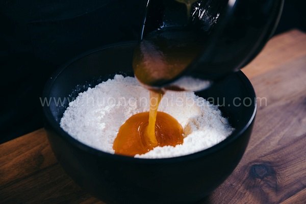 Đổ hỗn hợp nước đường vào bột mì đã rây mịn