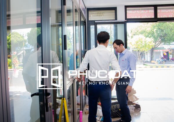 Khách hàng tham quan trải nghiệm để đặt làm cửa nhôm kính đẹp tại showroom Phúc Đạt.