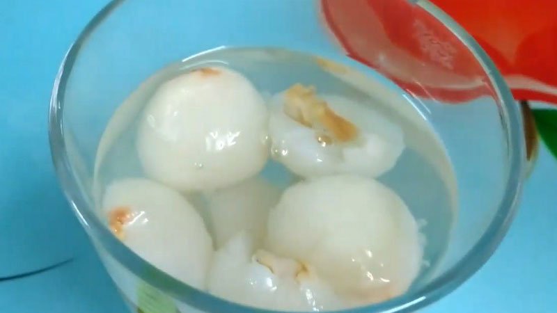 Cho một ít vào ly cùng với một ít nước vải và đường, khuấy đều cho đường tan, sau đó cho đá vào.