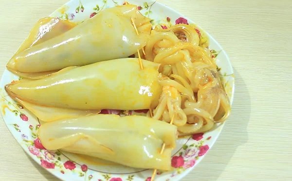 nhồi nhân vào bên trong mực và cố định lại bằng tăm tre