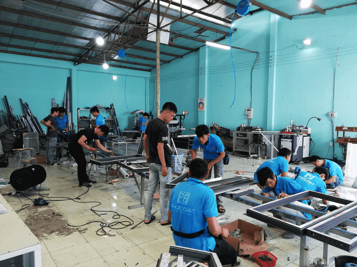 Thợ học việc học làm cửa nhôm hệ Xingfa tại xưởng nhôm kính Phúc Đạt.
